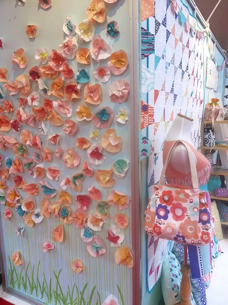 Cute wall in Art Gallery’s booth, love those paper flowers!
